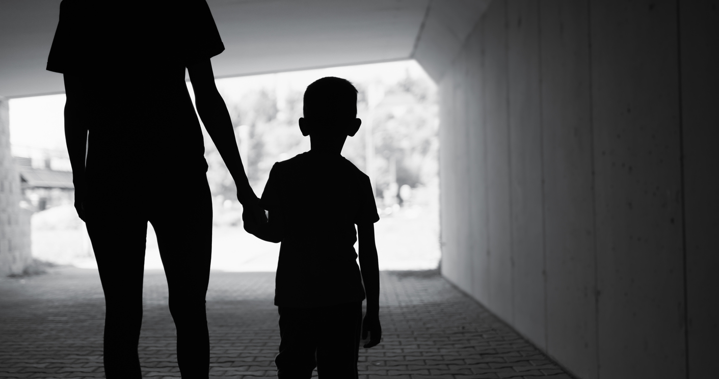 Madre o padre con niño de la mano y de espaldas